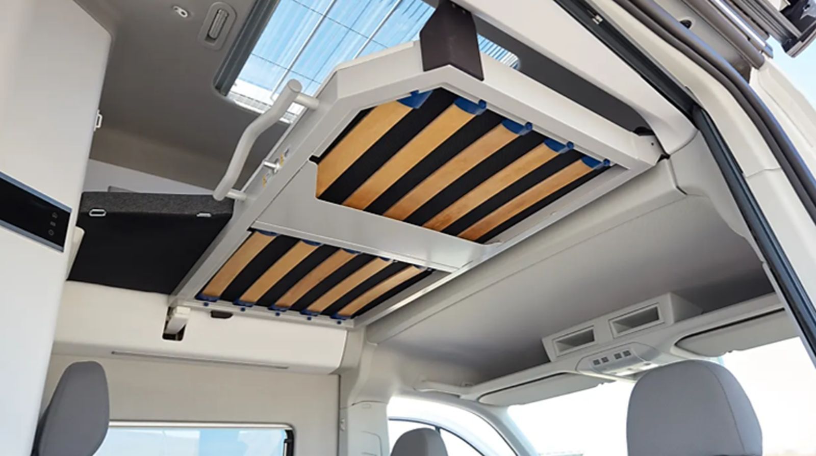 Ein Bett hängt von der Decke eines Lieferwagens.