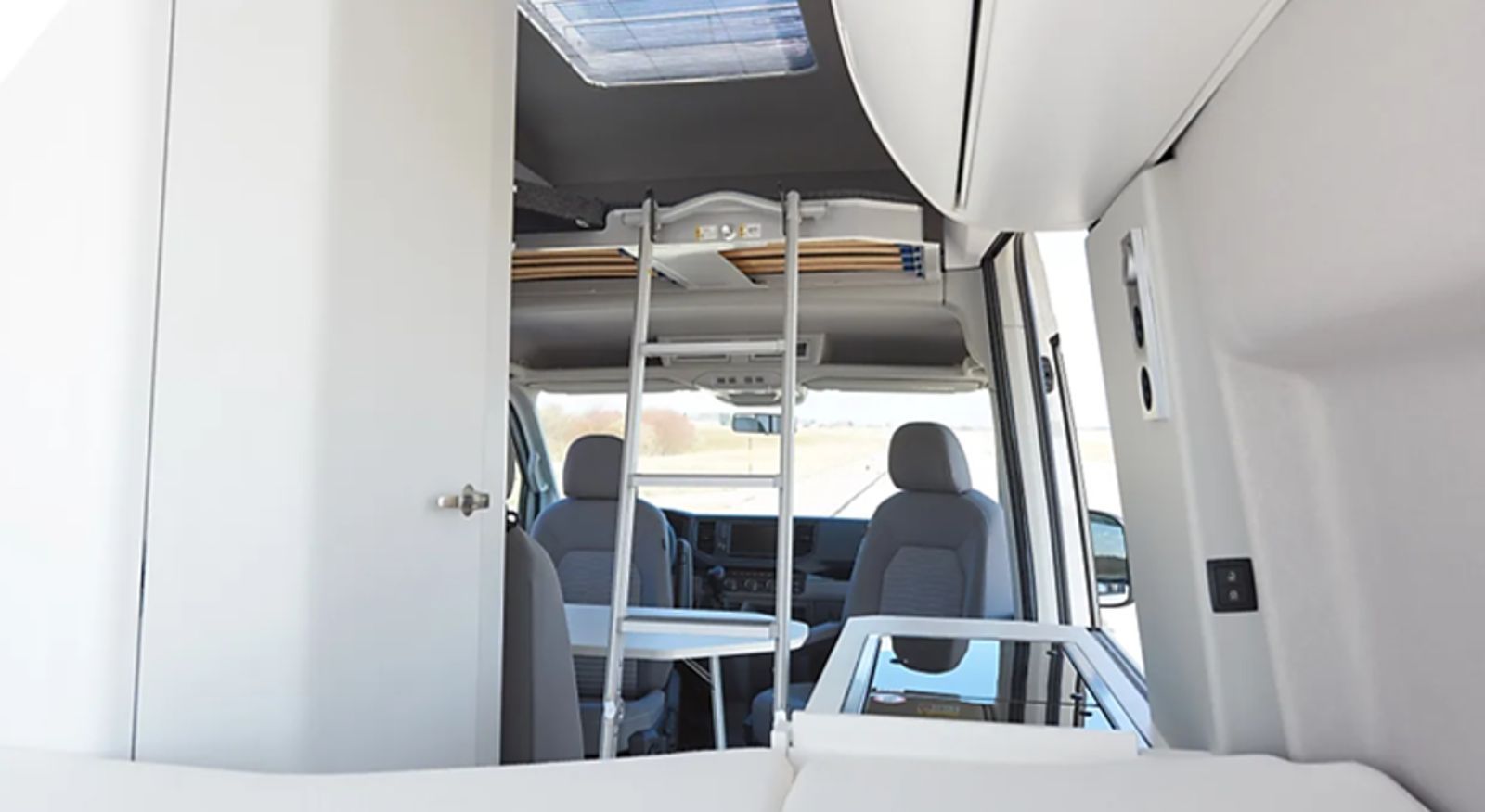 Das Innere eines Lieferwagens mit einem Etagenbett und einer Leiter.
