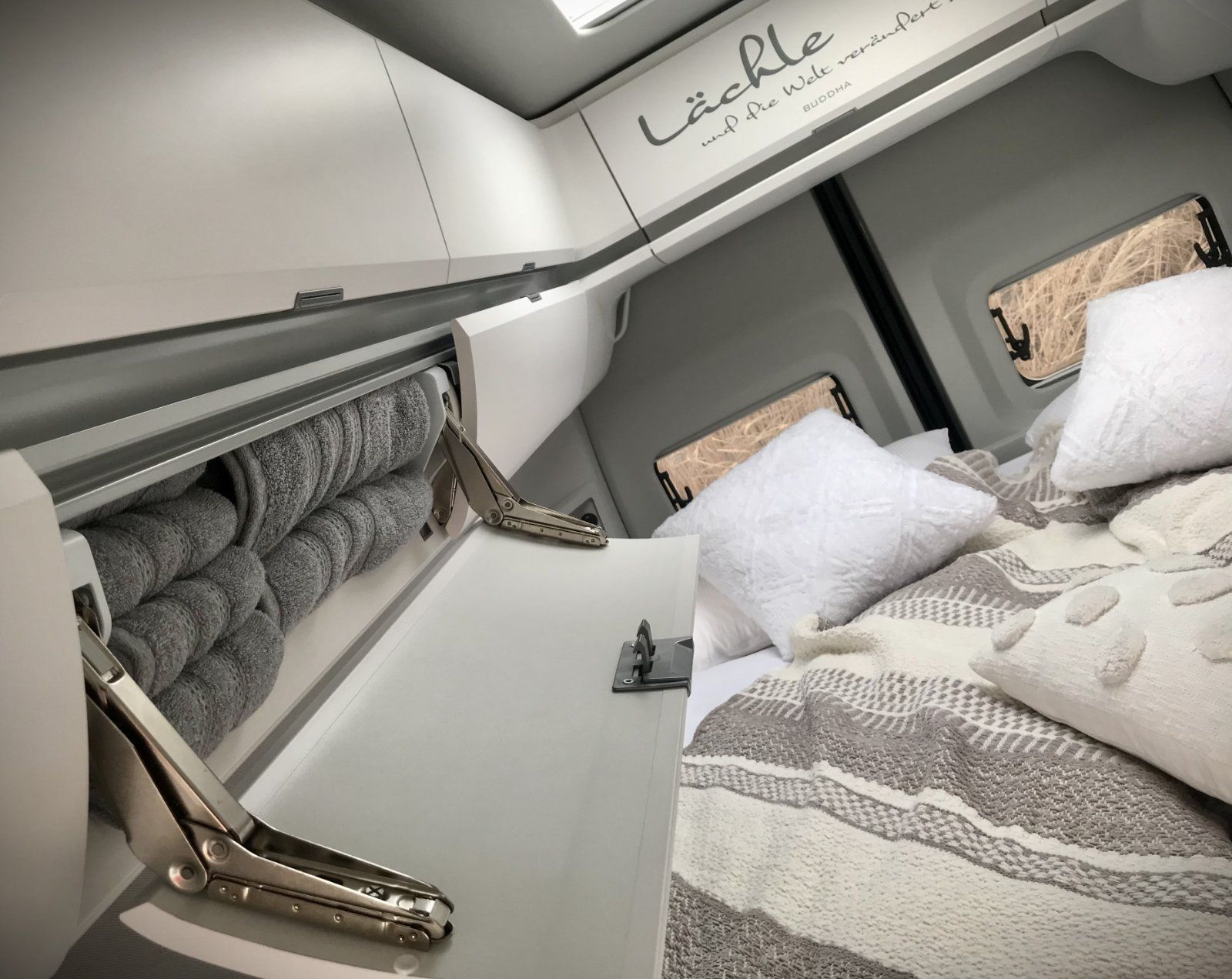 Ein Schlafzimmer mit einem Bett und einem Regal mit Handtüchern darin