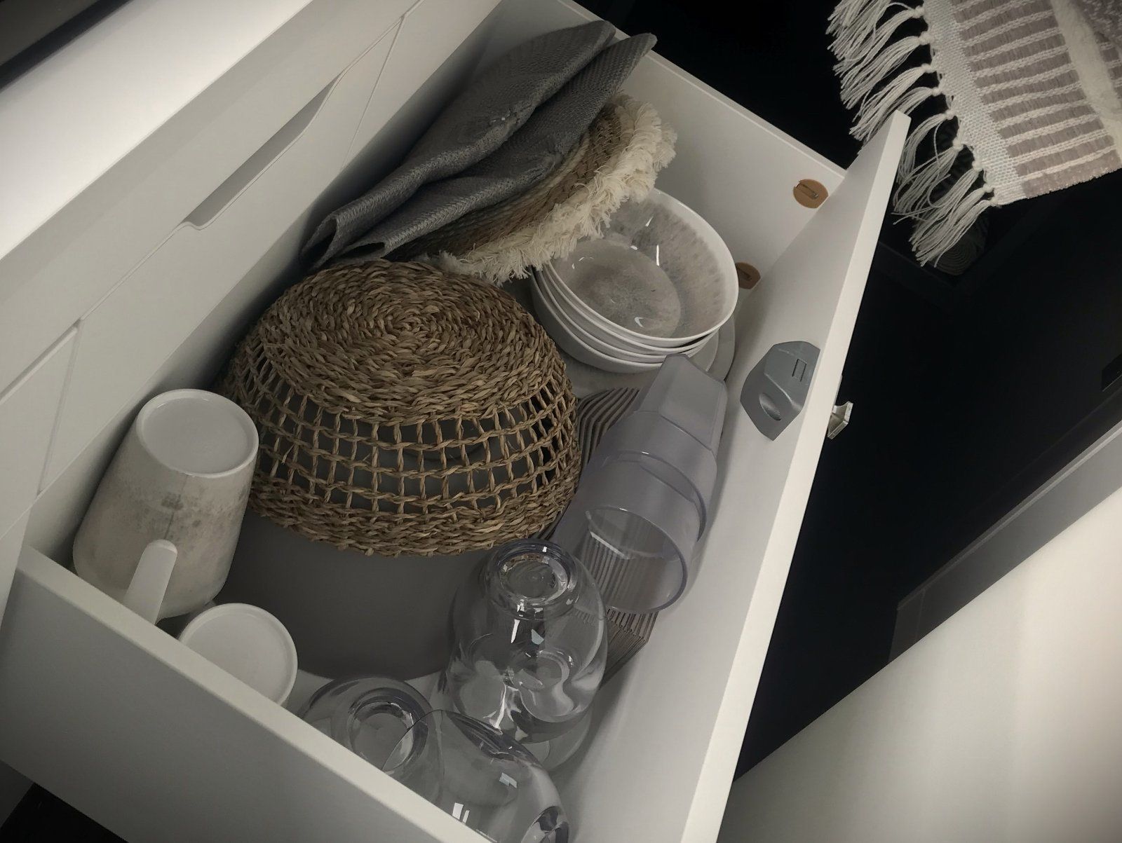 Eine weiße Schublade voller Schüsseln und Gläser