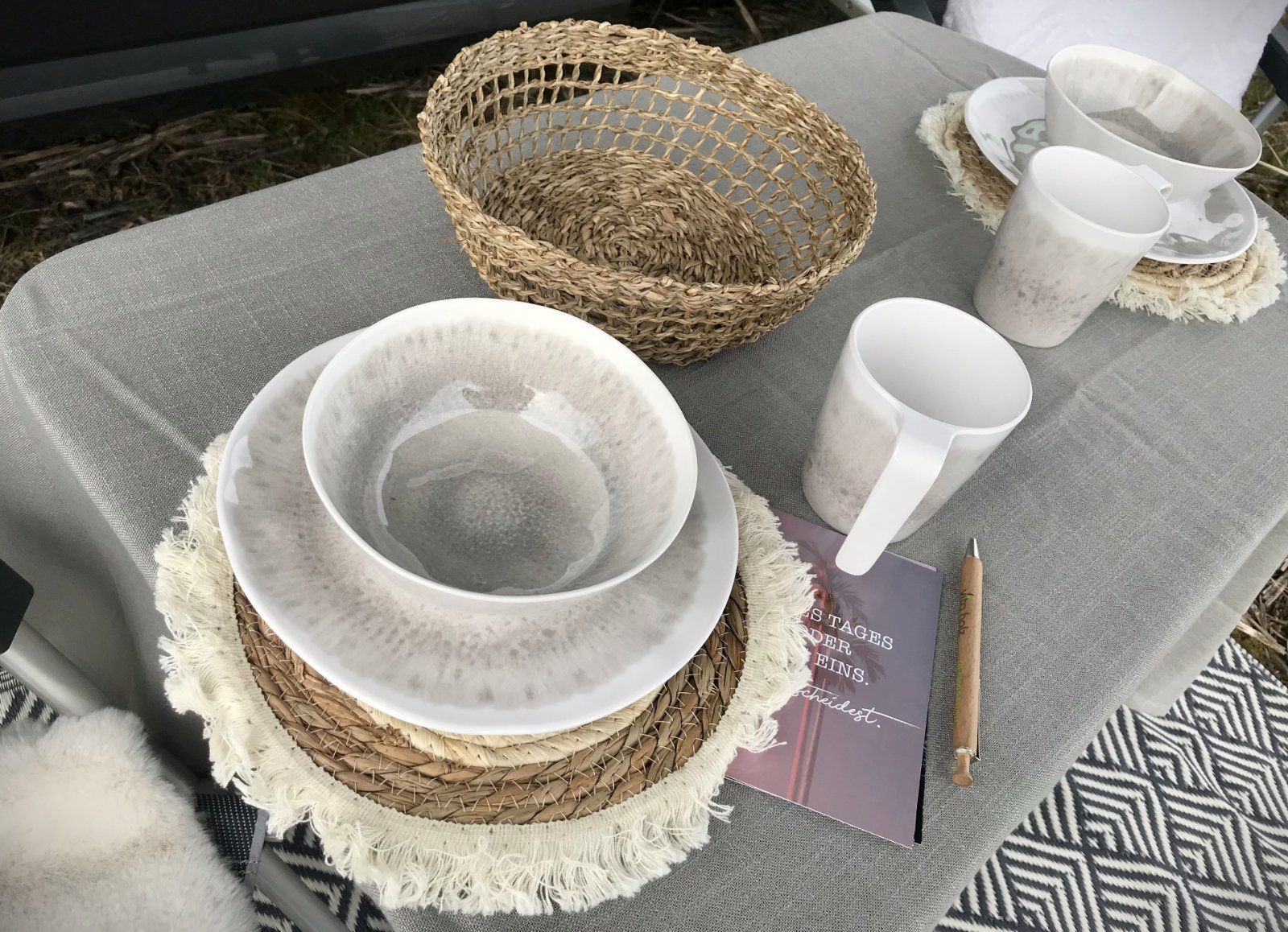 Ein Tisch mit Tellern, Schüsseln, Tassen und einem Korb darauf.