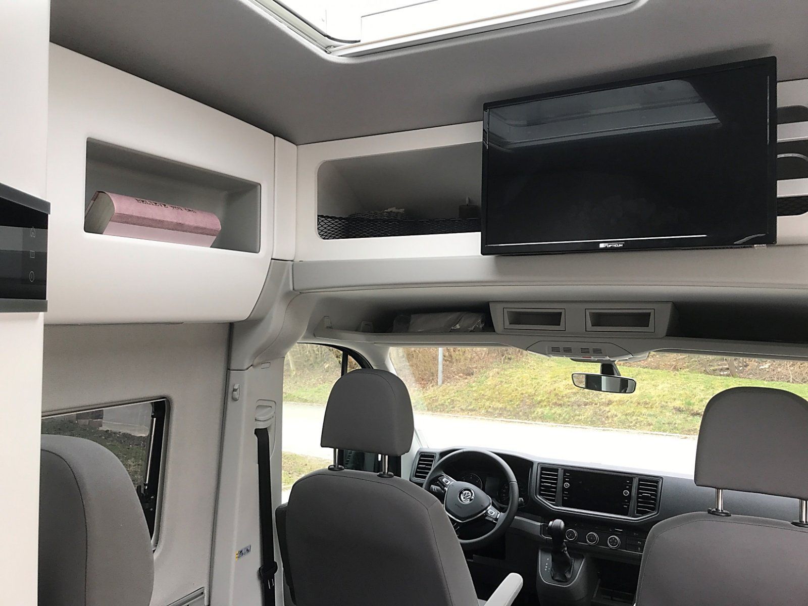 Ein Wohnmobil mit einem an der Decke montierten Flachbildfernseher.