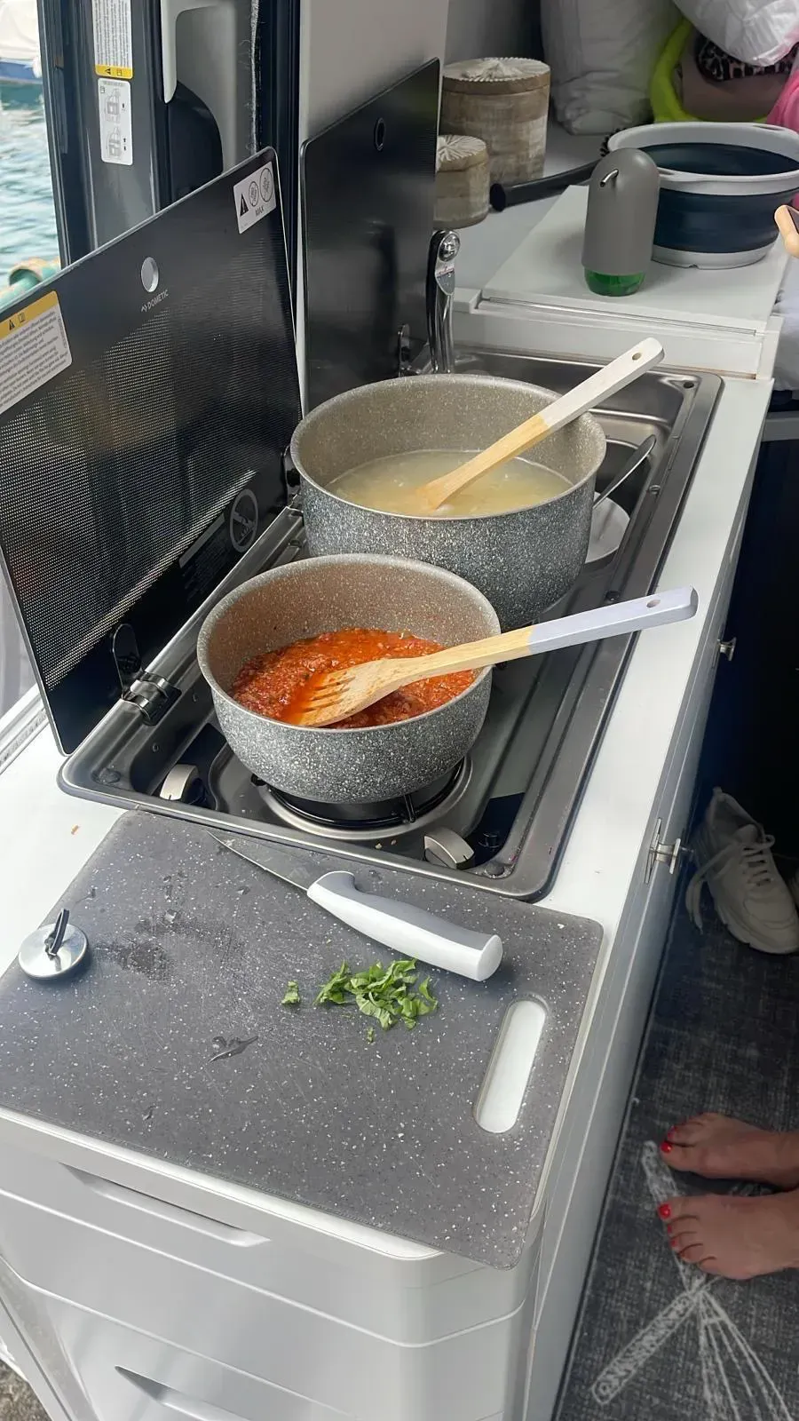 In einer Küche wird auf einem Herd in zwei Töpfen mit Essen gekocht.