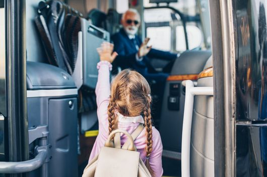 Jeune fille saluant le chauffeur de l'autocar