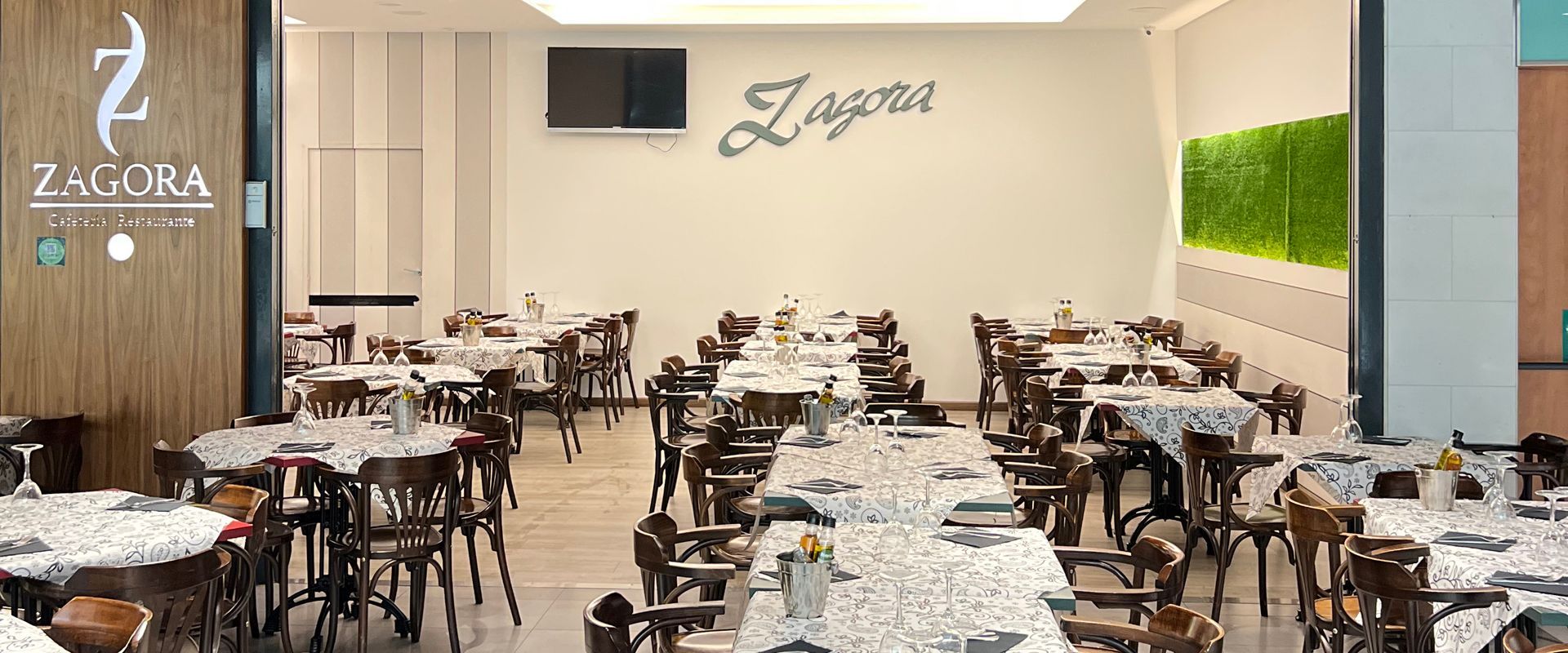 Interior de restaurante con mesas preparadas. El nombre