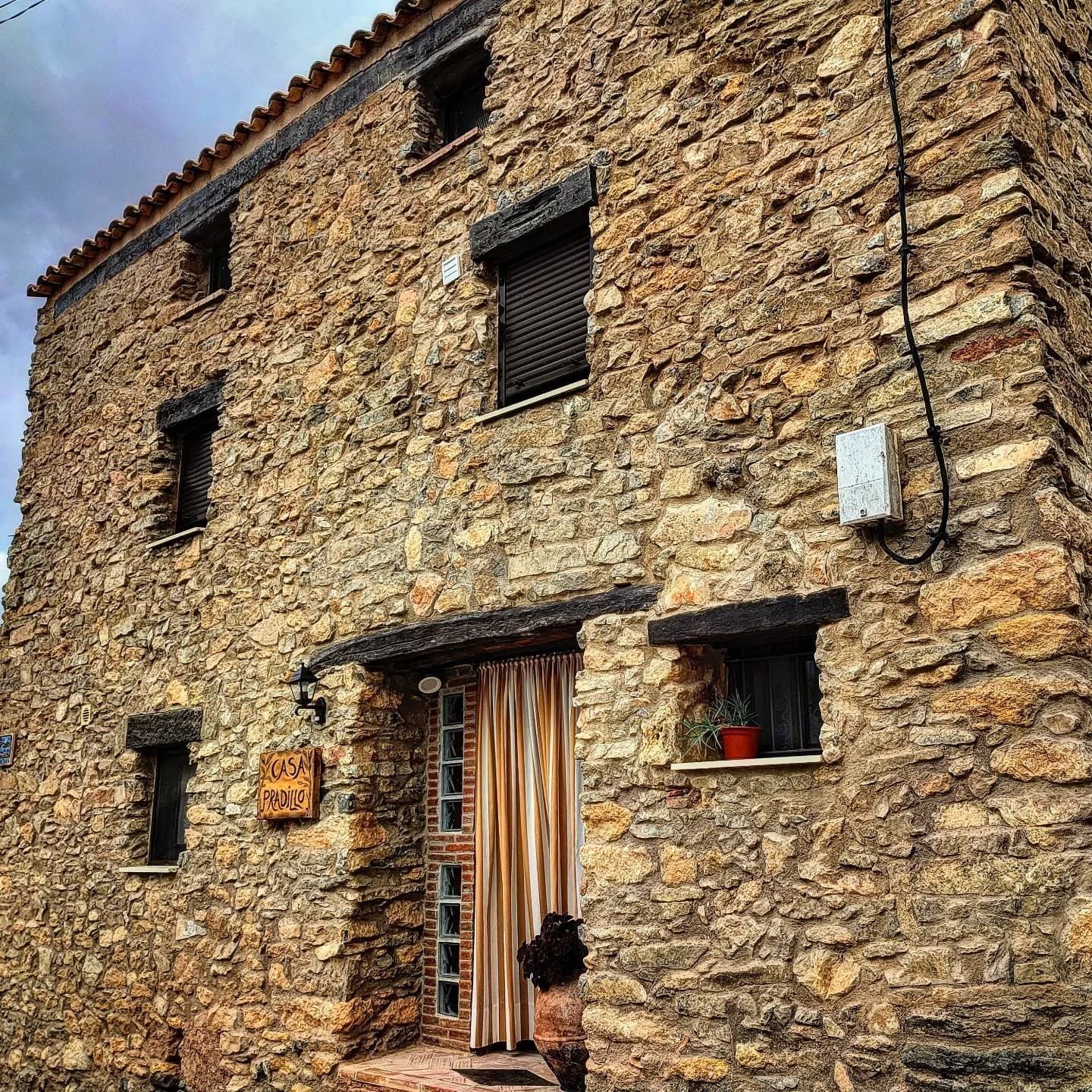 Un gran edificio de piedra con una puerta y ventanas de madera.