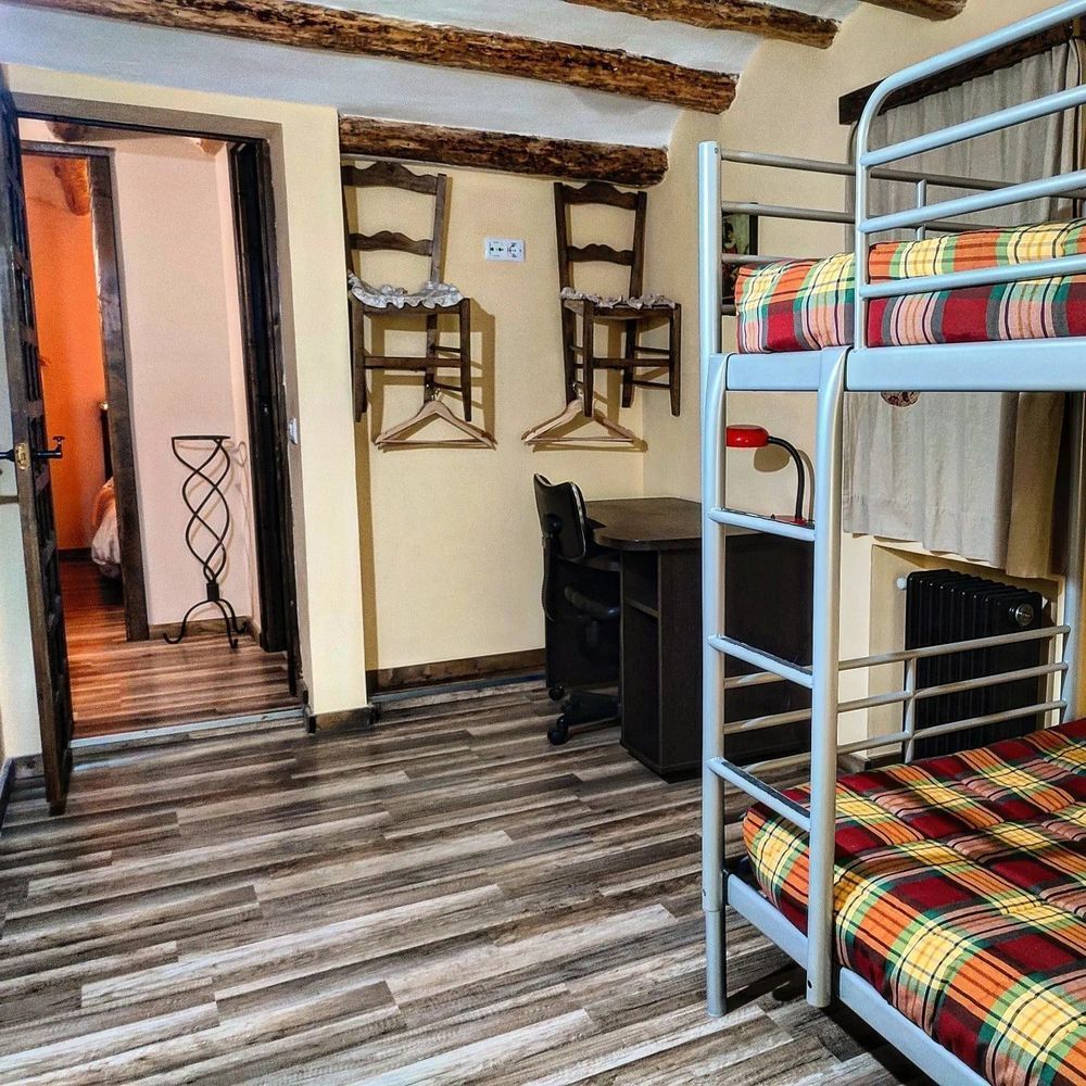 Un dormitorio con dos literas y un escritorio.