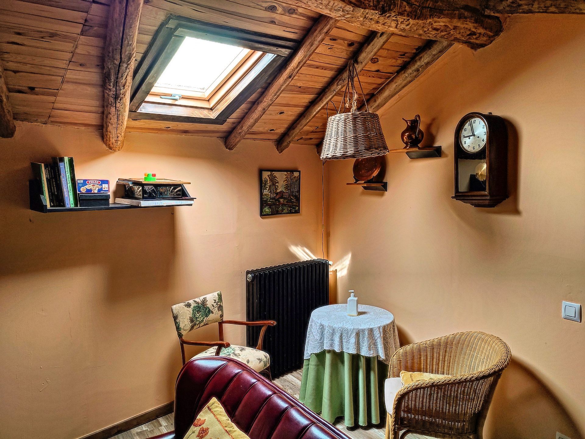 Una sala de estar con una mesa y sillas y un reloj en la pared.