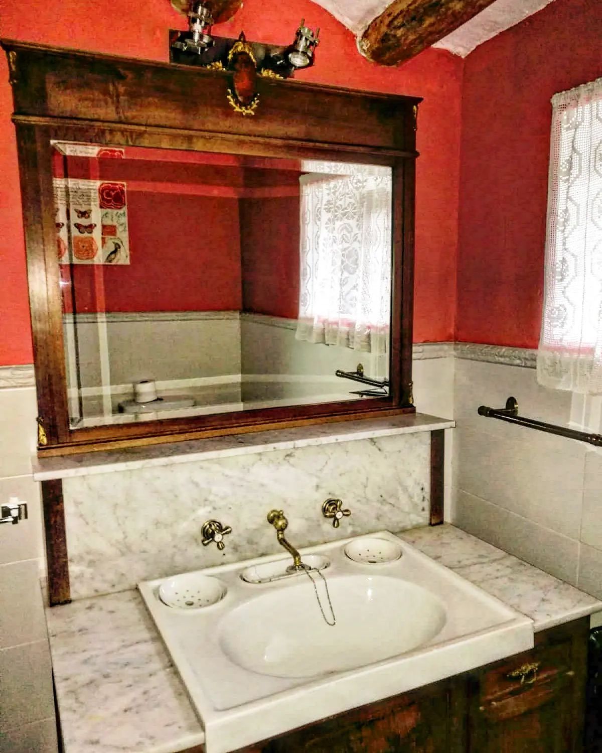 Un baño con lavabo, espejo y ventana.