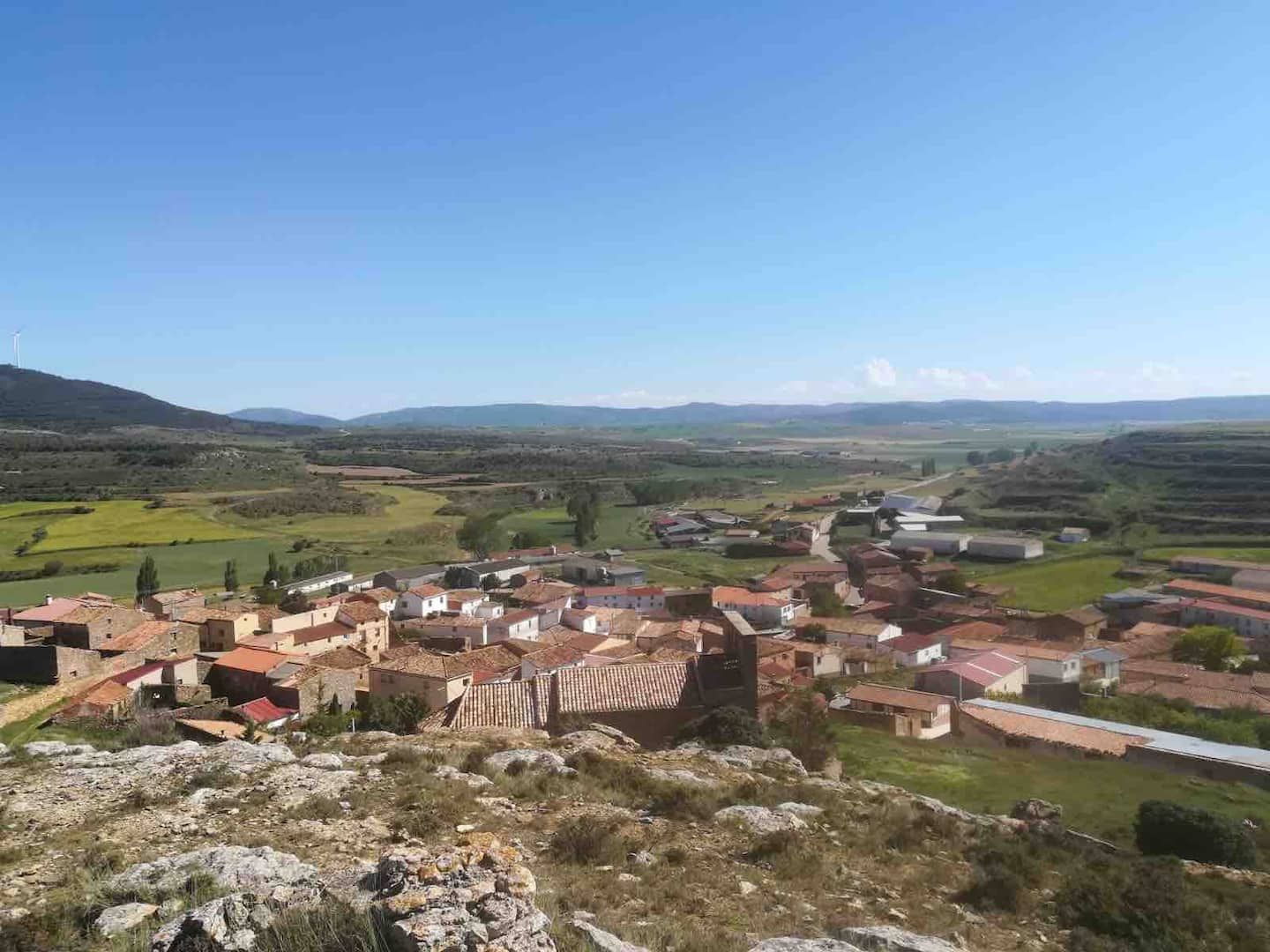 Un pequeño pueblo está situado en la cima de una colina en medio de un valle.