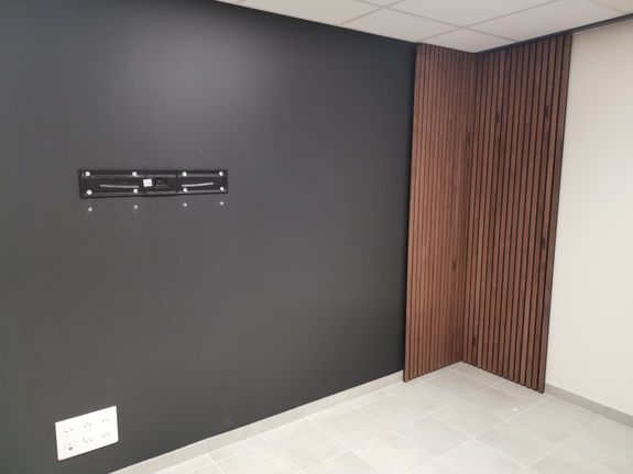 Mur gris et blanc et panneau en bois dans un coin