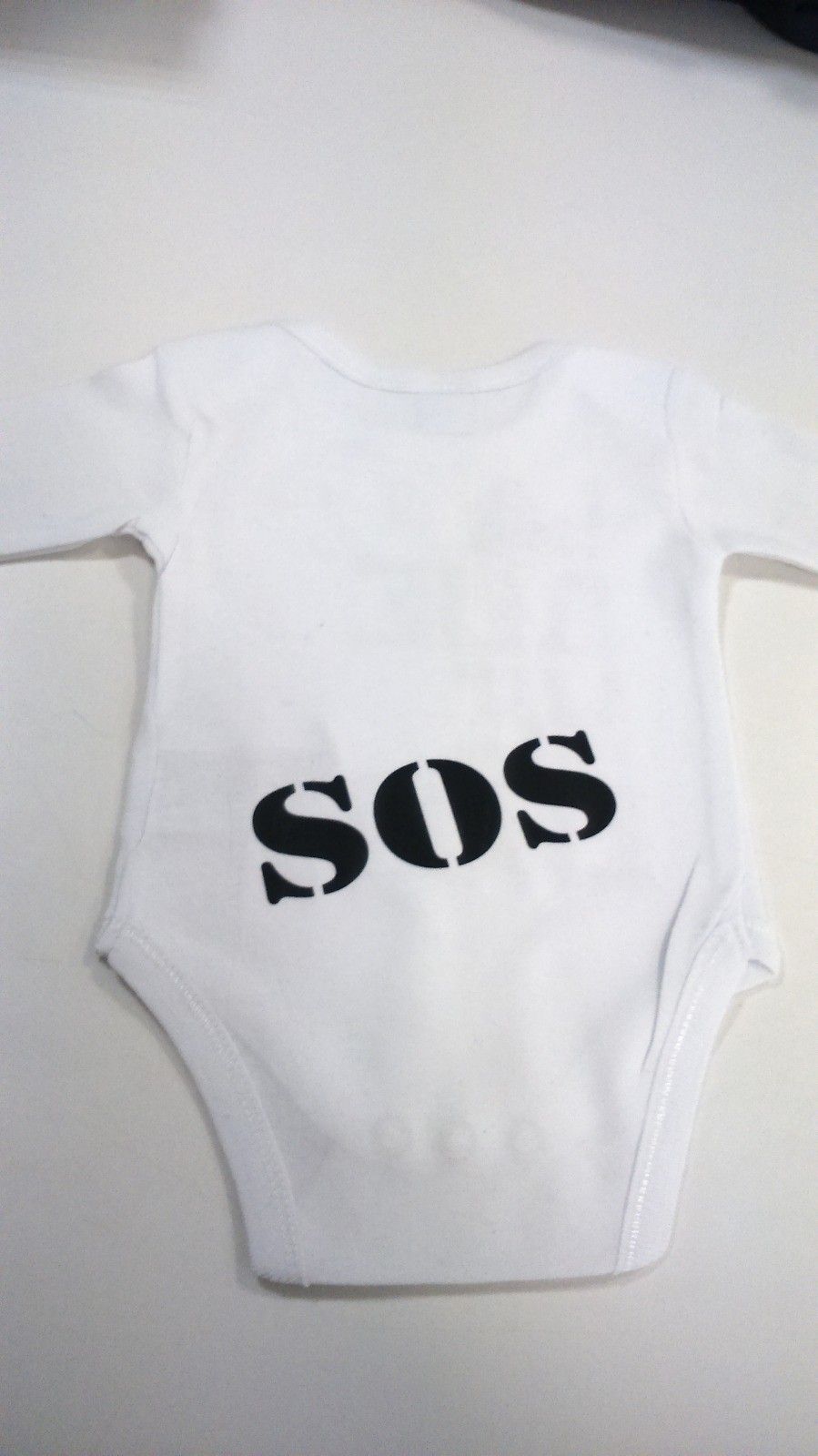 Body de bebé de color blanco con la palabra 