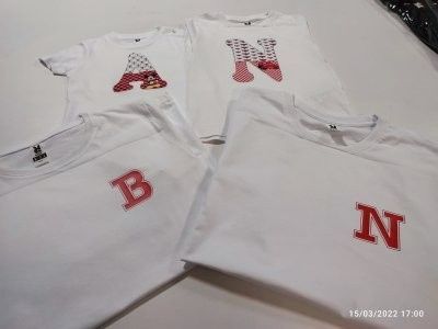 Cuatro camisetas blancas, cada una con una letra roja diferente (A, B, N, N) aplicada en la parte delantera.