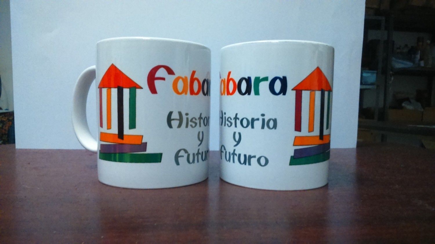 Dos tazas blancas con logotipos coloridos que dicen 