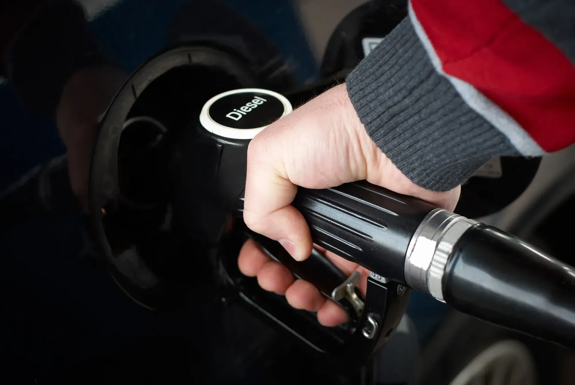Eine Person pumpt an einer Tankstelle Benzin in ein Auto