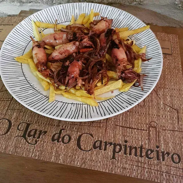 Un plato de comida reposa sobre un mantel que dice mar do carpinteiro