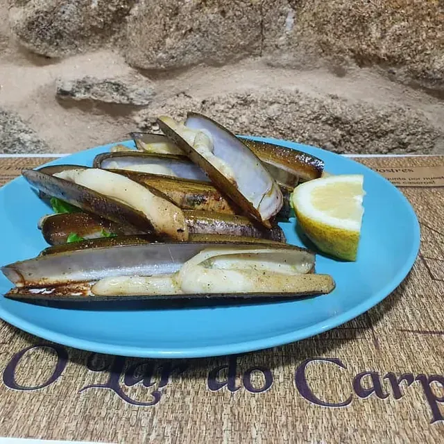 Un plato azul con una rodaja de limón encima.