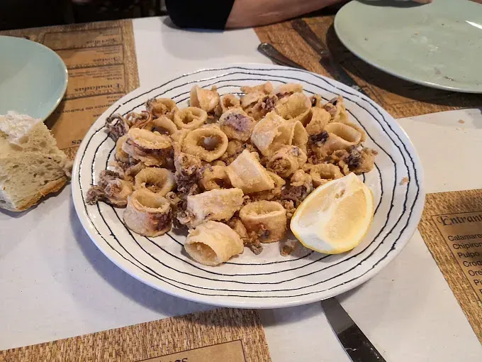 Un plato de comida con una rodaja de limón encima.