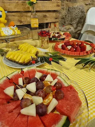 Una mesa cubierta con sandía, uvas y piña.
