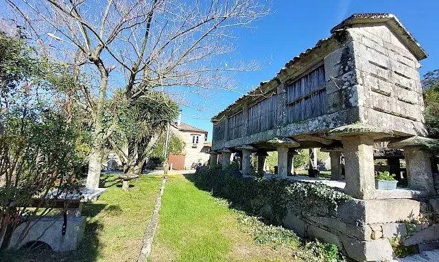Un gran edificio de piedra se encuentra en medio de un campo de hierba.