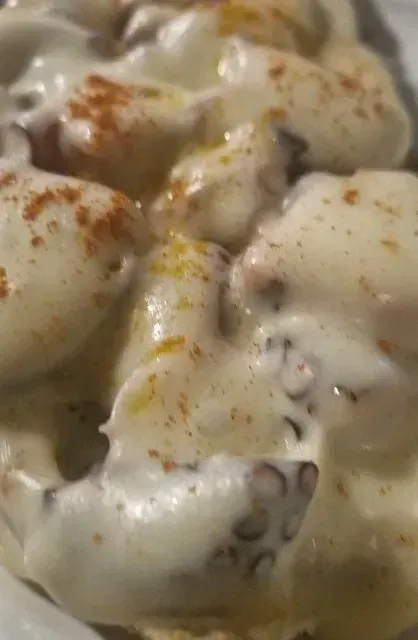 Un primer plano de un plato de comida con salsa encima.