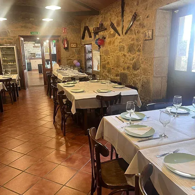 Un comedor largo con mesas y sillas preparadas para comer.