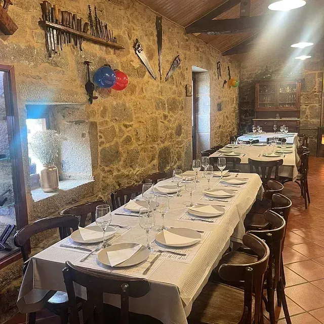 Una mesa larga con platos y vasos encima en un restaurante.