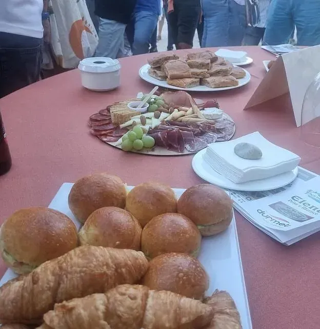 Varios platos de comida en una mesa, incluidos croissants.