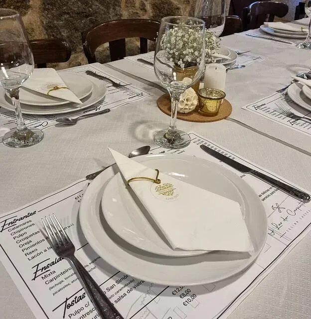 Una mesa con platos y cubiertos y un mantel individual que dice