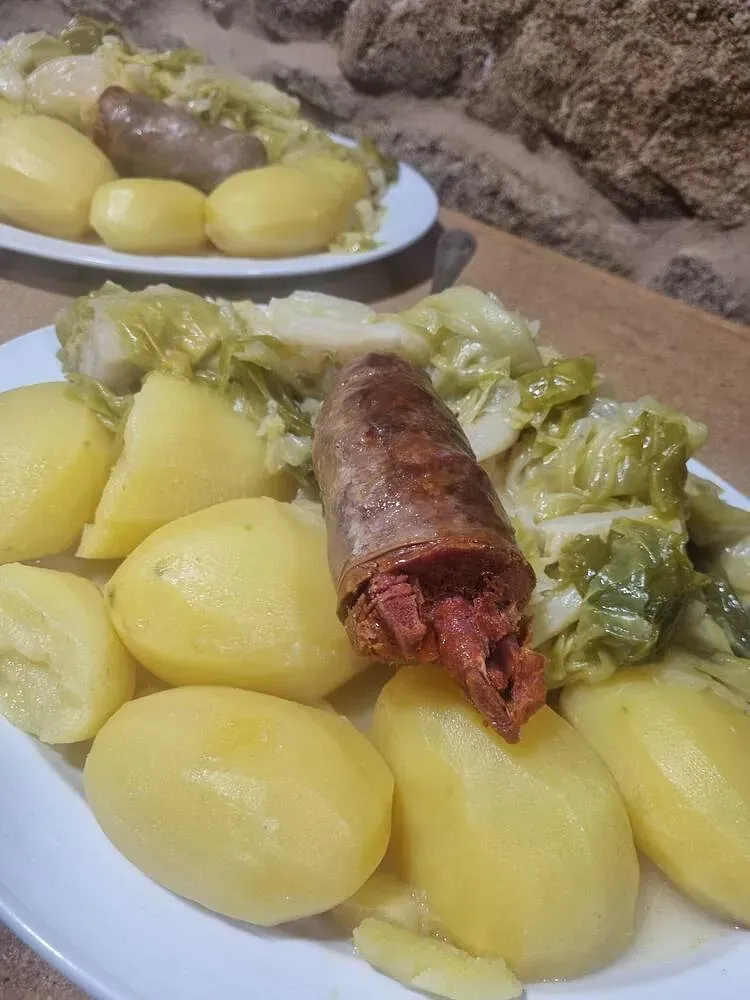 Un plato de comida con patatas y repollo en una mesa.