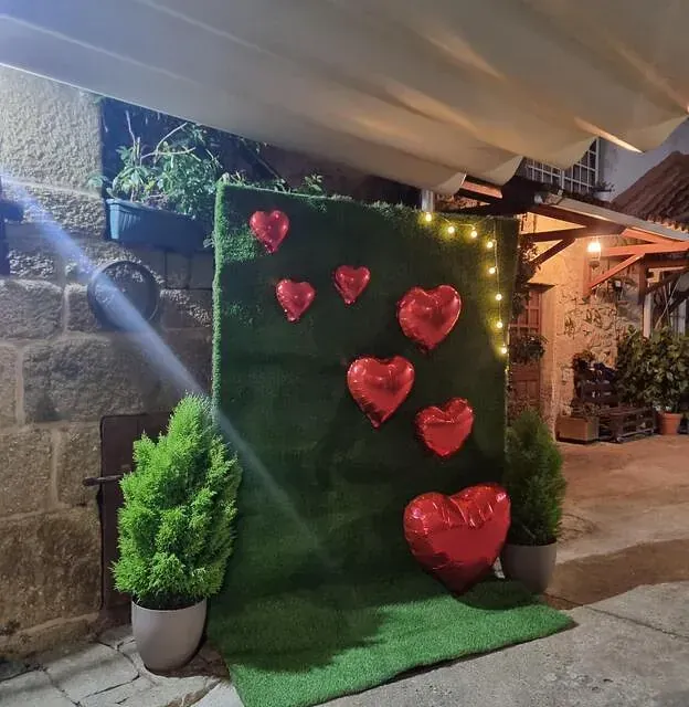 Una pared verde con globos en forma de corazones