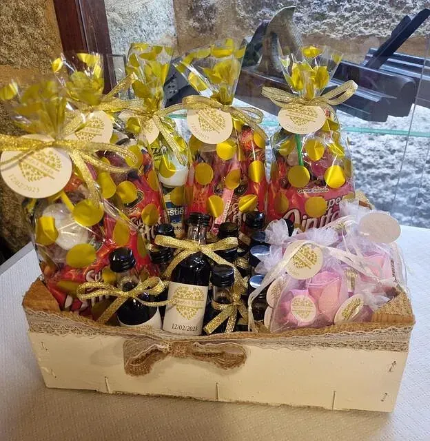 Una canasta llena de botellas y bolsas de dulces, incluida una que dice