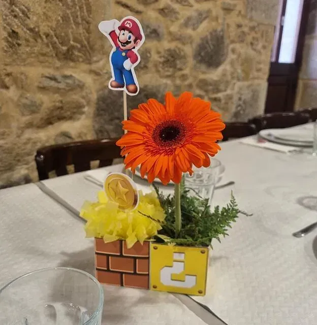 Un centro de mesa de Mario con una flor y un ladrillo con la letra c.