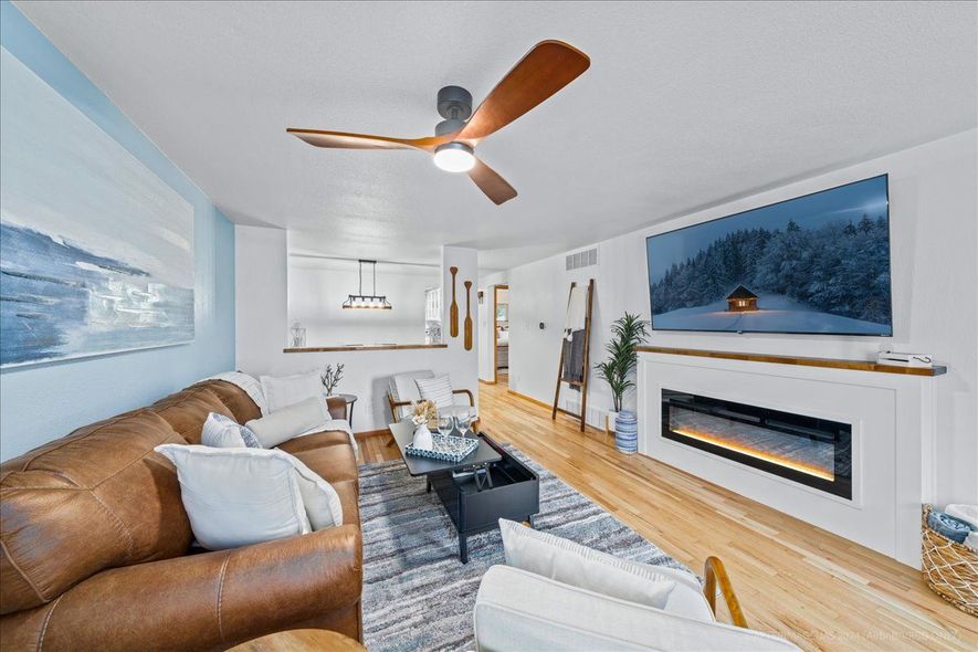 Bright living room with two armchairs, round table, floor lamp, and large window