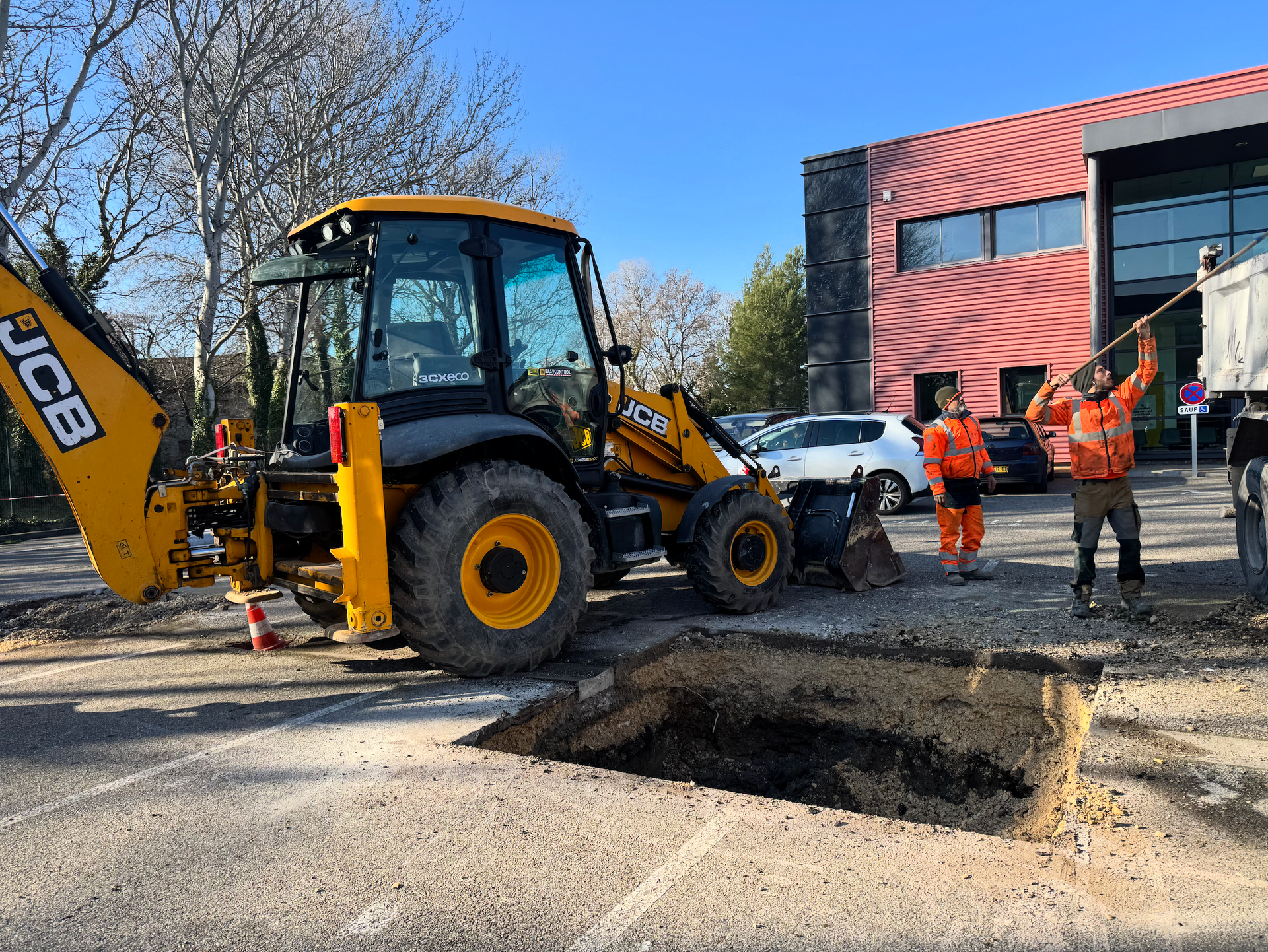 Engin JCB et ouvriers SARL STS en pleine opération de terrassement à Sorgues pour préparation de fondation béton