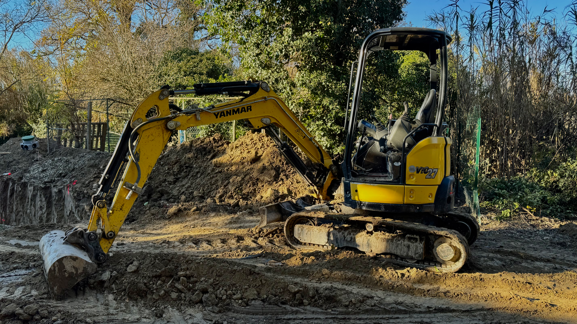Mini-pelle Yanmar en action pour des travaux de terrassement et d’assainissement sur un chantier à Caumont.