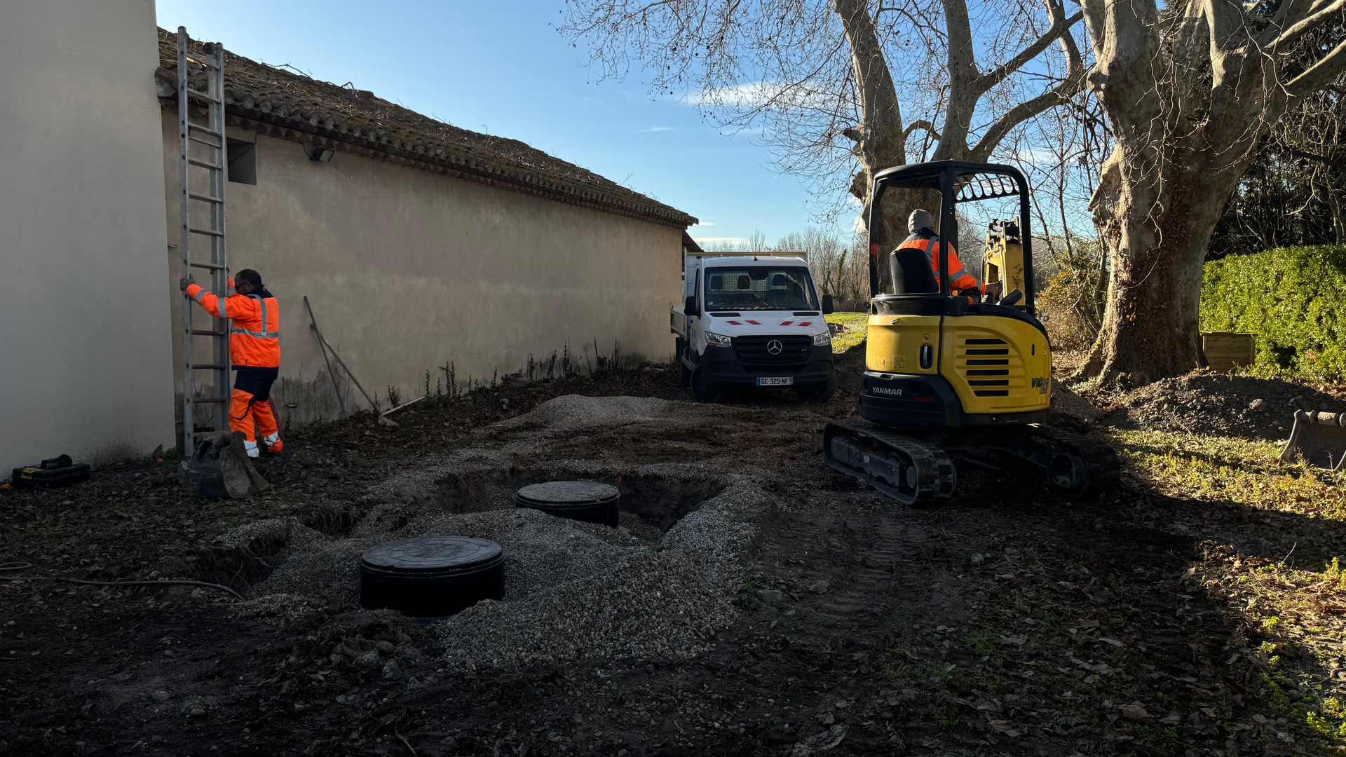 Travaux d’installation d’un système d’assainissement avec mini-pelle et techniciens sur un chantier dans le Vaucluse.