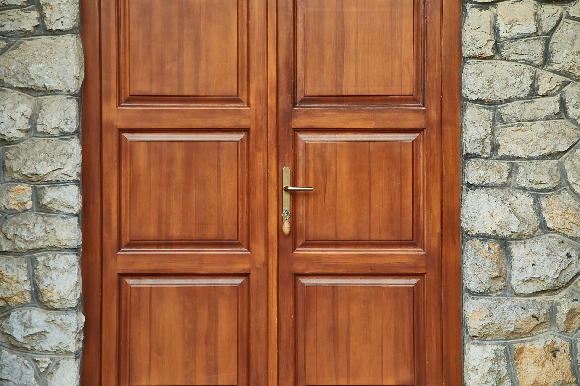 Una puerta de madera está situada delante de una pared de piedra.