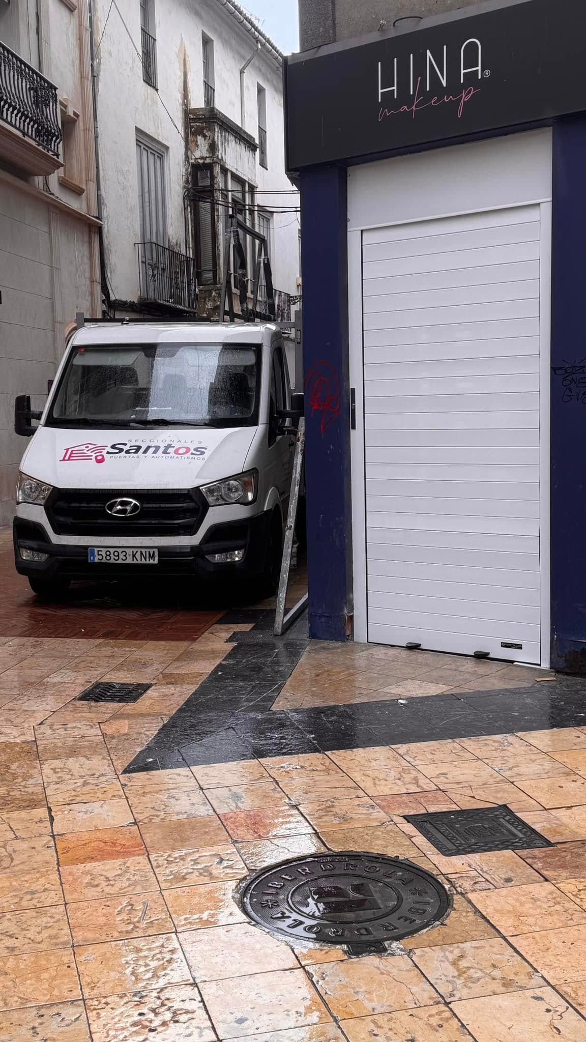 Una camioneta blanca está estacionada frente a un edificio.
