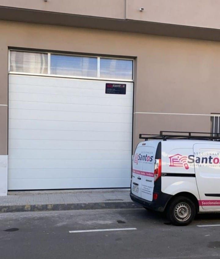 Una camioneta de Santos está estacionada frente a un edificio