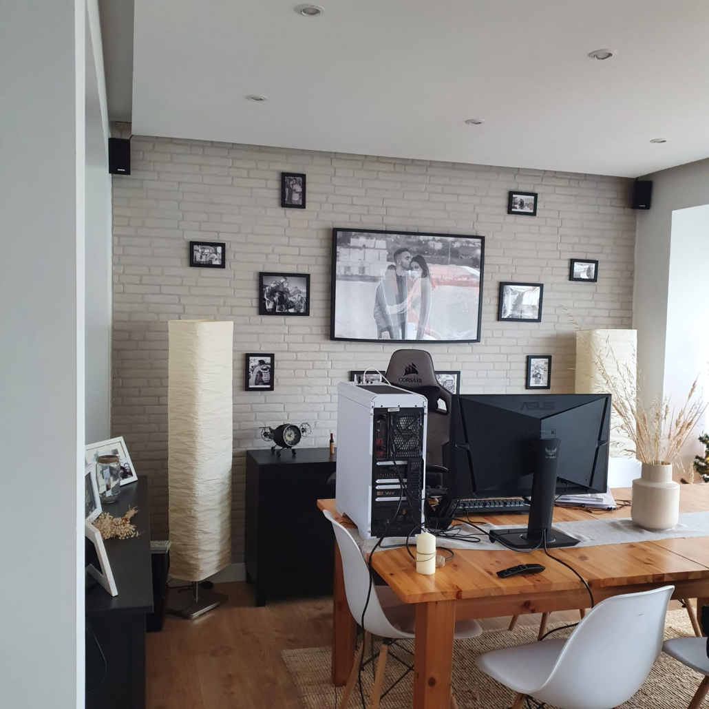 Una sala de estar con una mesa y sillas de madera y una computadora encima.