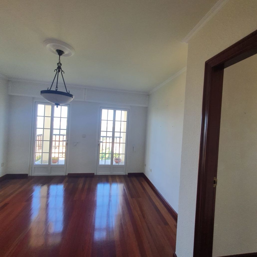 Una habitación vacía con una lámpara de araña colgando del techo.