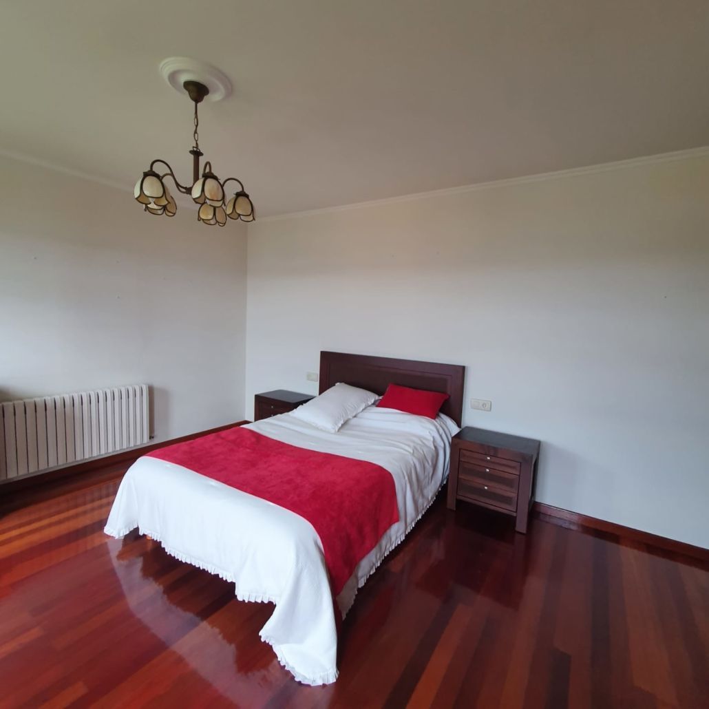 Un dormitorio con una cama y una lámpara de araña colgando del techo.