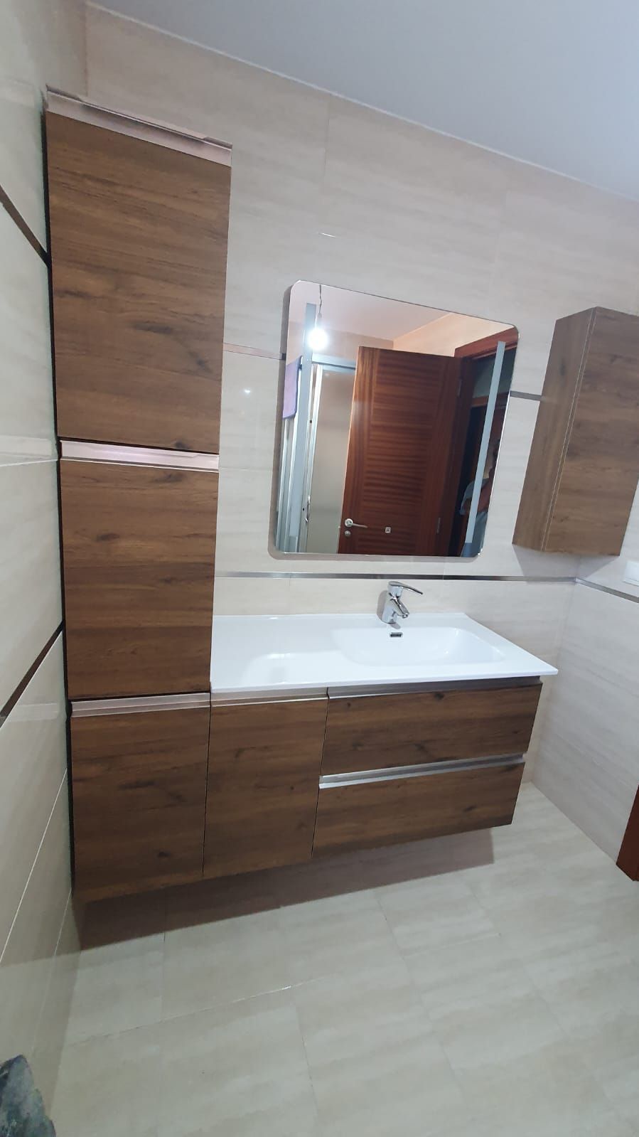 Un baño con lavabo, espejo y muebles de madera.