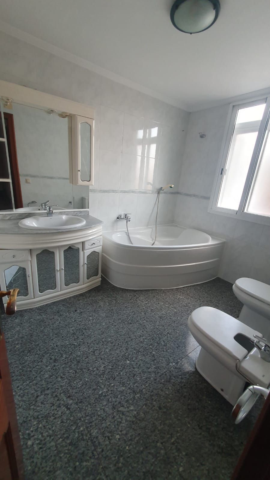 Un baño con bañera, inodoro, lavabo y espejo.