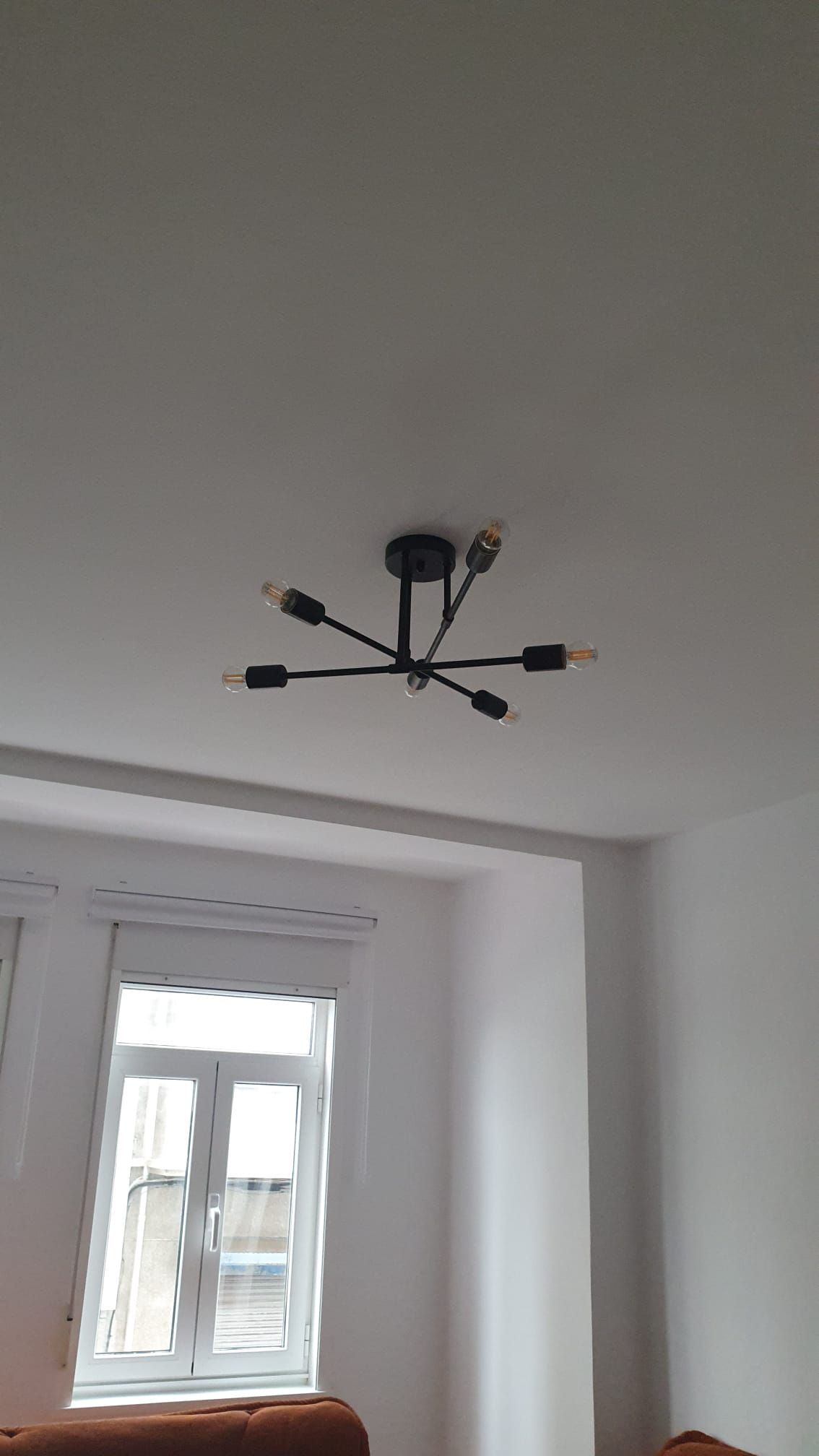 Una sala de estar con una lámpara de araña colgando del techo.