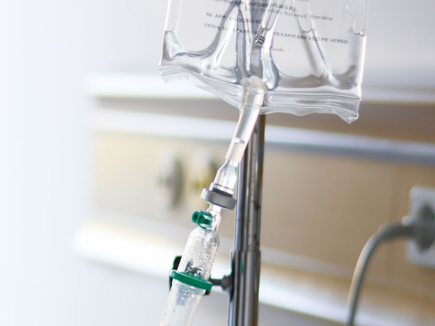 Poche de perfusion intraveineuse suspendue à un support dans un environnement médical.