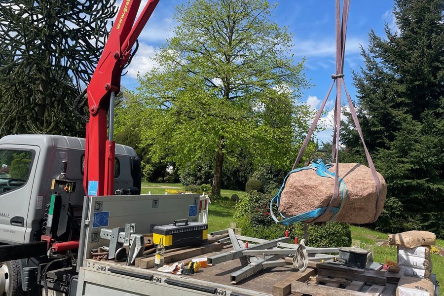 A large rock is sitting on the back of a truck.