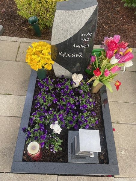 Ein Grab für Andrej Krieger mit Blumen und Kerzen
