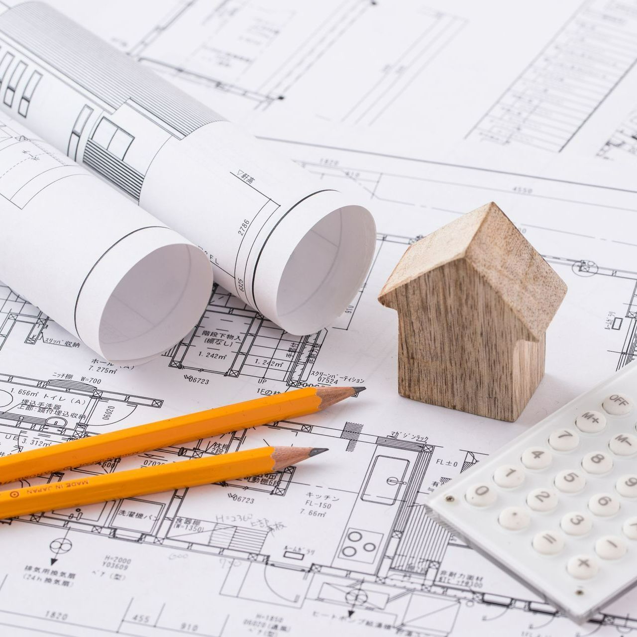Un plan, une petite maison en bois et une calculette